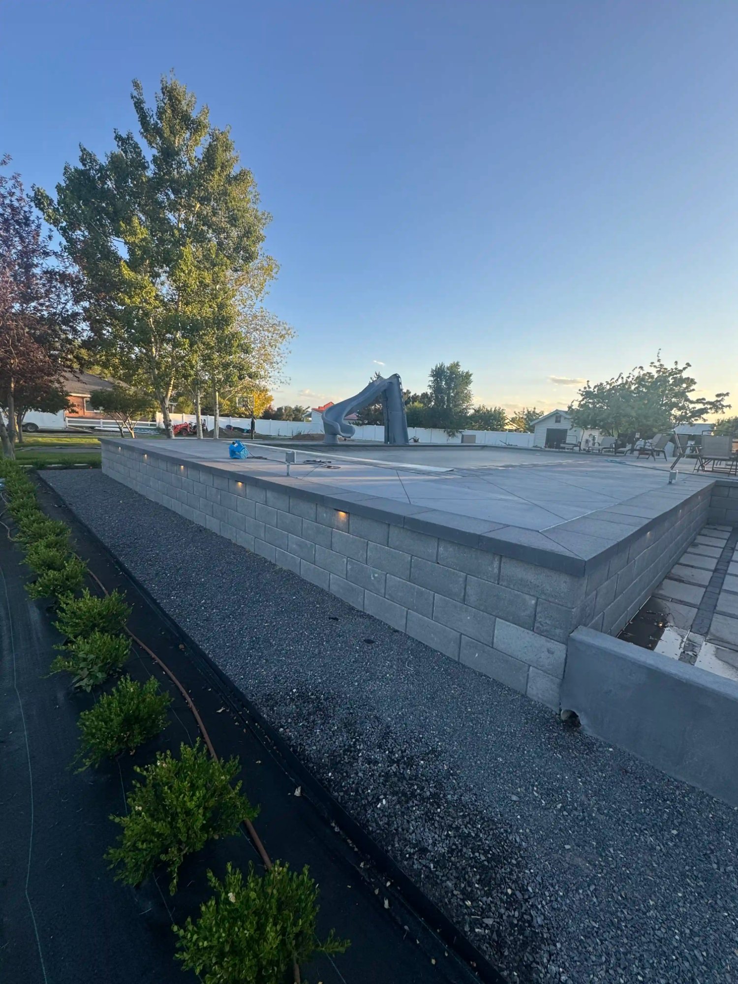 Pool deck retaining wall with CMU stone construction Northern Utah by EC Pools